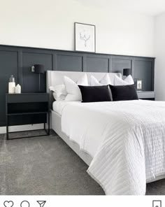 a bed with white sheets and black pillows