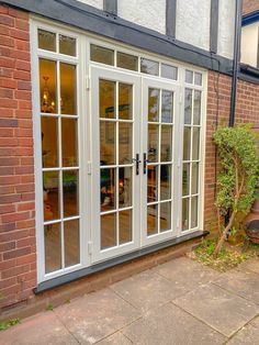 an outside view of a house with french doors and brick walls, including a patio