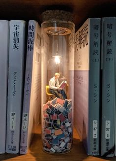 a jar filled with books sitting on top of a wooden shelf next to stacks of books