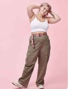 a woman in white tank top and khaki cargo pants posing for the camera