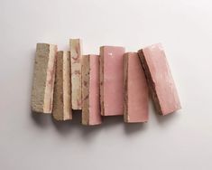 several pieces of pink and brown soap sitting next to each other on a white surface