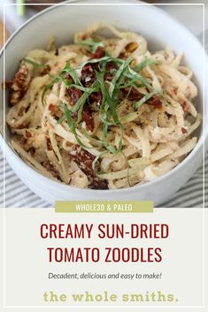 a white bowl filled with pasta and garnish on top of a striped table cloth