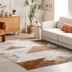 a living room filled with furniture and a large rug on top of a wooden floor