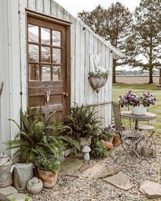 an old shed is filled with potted plants and other outdoor decorating items in front of the door