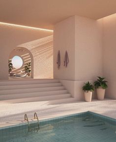 an indoor swimming pool with steps leading up to it and potted plants on the side