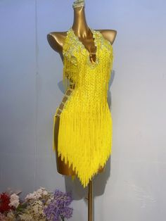 a mannequin wearing a yellow flap dress with fringes on it's sides