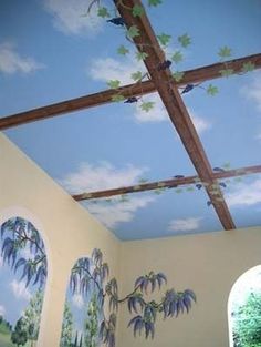 the ceiling in this bedroom is painted with blue and green leaves