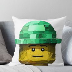 a lego man wearing a green helmet on top of his head throw pillow with the image of a lego man's face