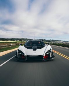 a white and black sports car driving down the road