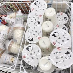 a shopping cart filled with lots of different types of baby food in plastic cups and saucers