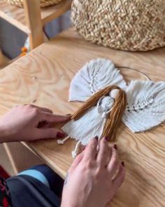 someone is making a angel decoration on the table