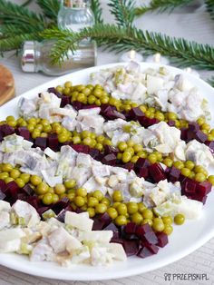 a platter filled with different types of food on top of a table next to pine branches