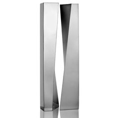 a tall metal vase sitting on top of a table