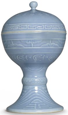 a blue vase with an intricate design on the top is shown in front of a white background