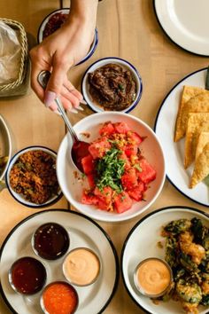 a table topped with plates and bowls filled with different types of food on top of it