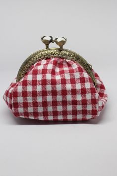 a red and white checkered purse sitting on top of a table