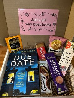 a box filled with books and chocolates next to a sign that says just a girl who loves books