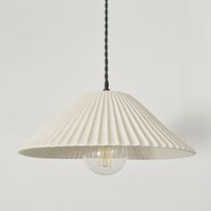 a white lamp hanging from a ceiling with a light bulb on it's side