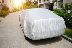 a car covered in white cloth parked on the street