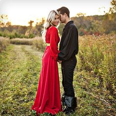 a man and woman standing next to each other in the grass