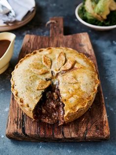 a meat pie on a wooden cutting board