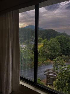 the view from inside a hotel room looking out onto a parking lot and mountains in the distance