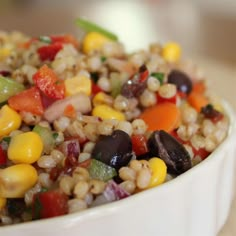 a white bowl filled with corn and vegetables