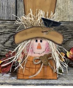 a scarecrow wearing a hat and holding a bird