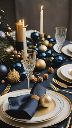 the table is set for christmas dinner with blue and gold decorations