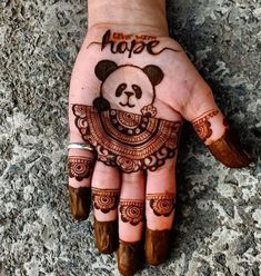 a woman's hand painted with henna and a panda bear on top of it