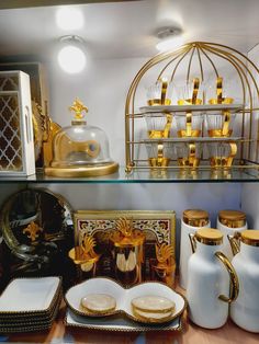 gold and white dishes on display in a store