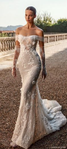 a woman in a wedding dress standing on the ground with her hand on her hip