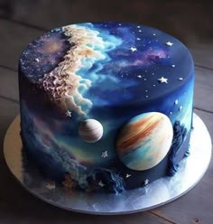 a cake decorated with the planets and stars on it's icing, sitting on top of a wooden table