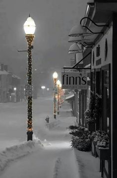 a street light covered in snow next to buildings