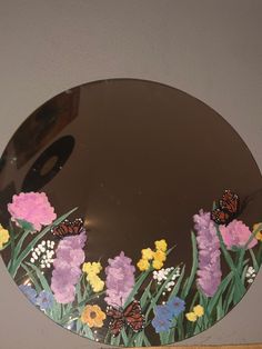 a mirror with butterflies and flowers painted on it