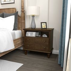 a bedroom with a bed, nightstand and pictures on the side table in front of it