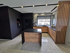 an empty kitchen with black walls and wooden accents on the countertop, along with marble flooring