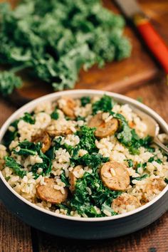 a bowl filled with rice and vegetables on top of a wooden table