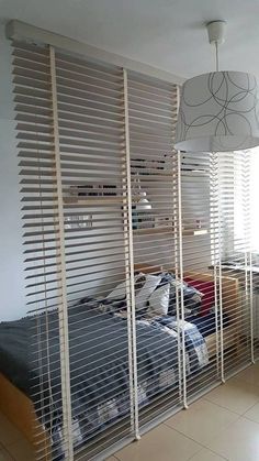 a bedroom with a bed and some blinds on the wall