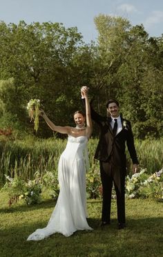 a bride and groom are holding flowers in their hands as they pose for the camera