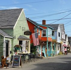 an american flag hanging on the side of a building next to tables and chairs in front of it