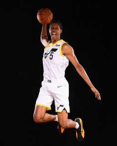 a basketball player is jumping in the air with his foot up and holding a ball