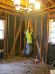 a man working on the ceiling in a room under construction