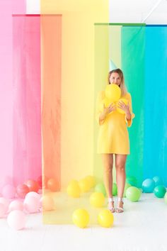 a woman in a party hat walking past balloons