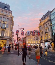 people are walking down the street at dusk