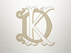 the letter k is made up of lines and swirls in gold on white paper