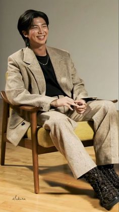 a man sitting in a chair smiling at the camera