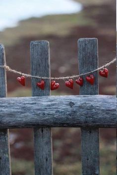 a wooden fence with hearts hanging from it