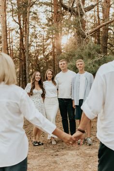 a group of people holding hands in the woods