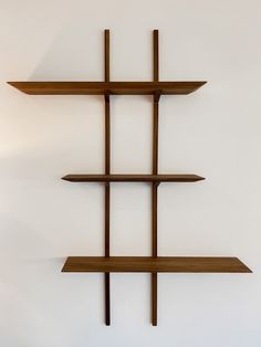 three wooden shelves on the wall, one with four intersecting sections and one without two